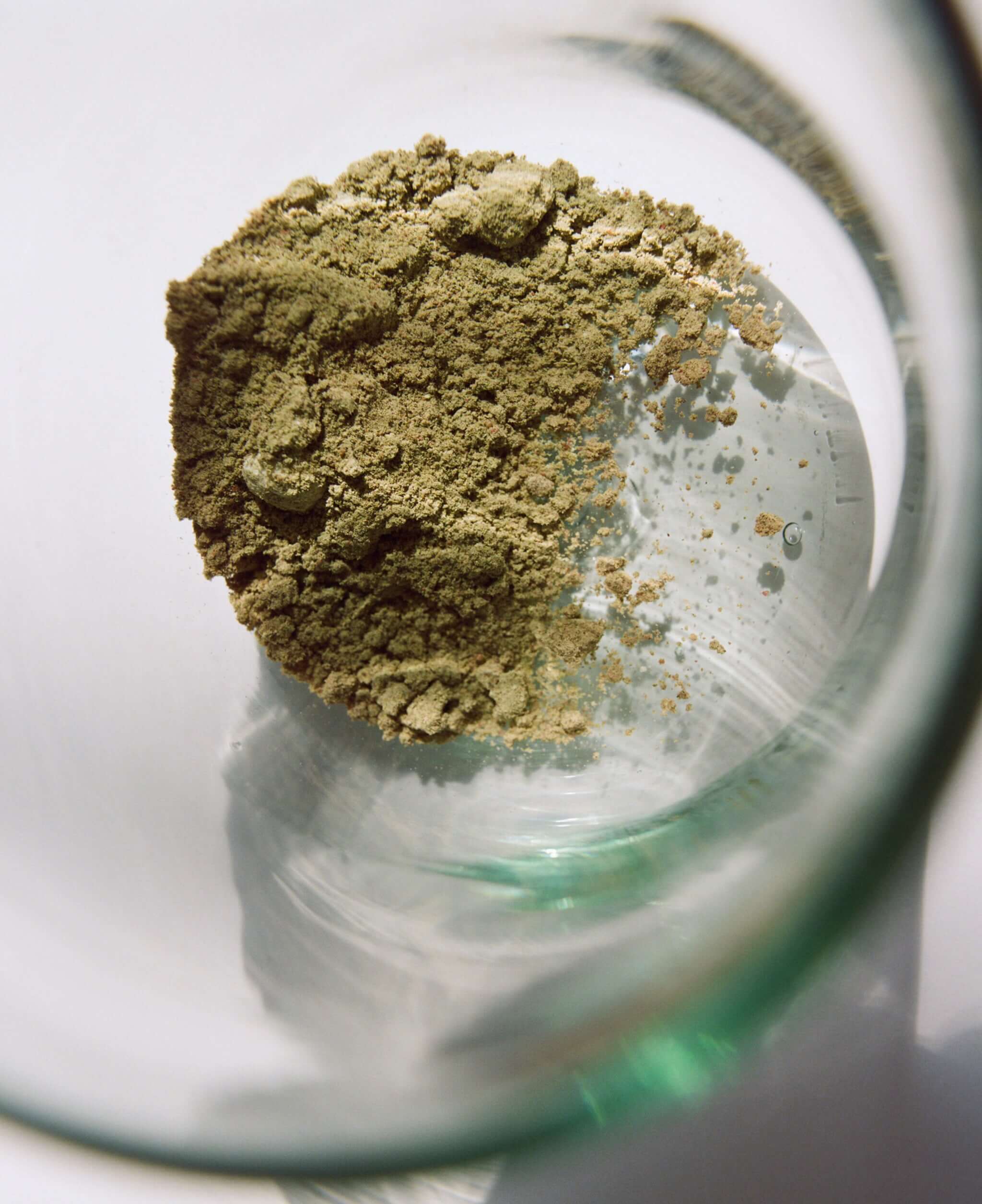 Best organic superfood powder for energy in a glass, showcasing its textured organic ingredients.